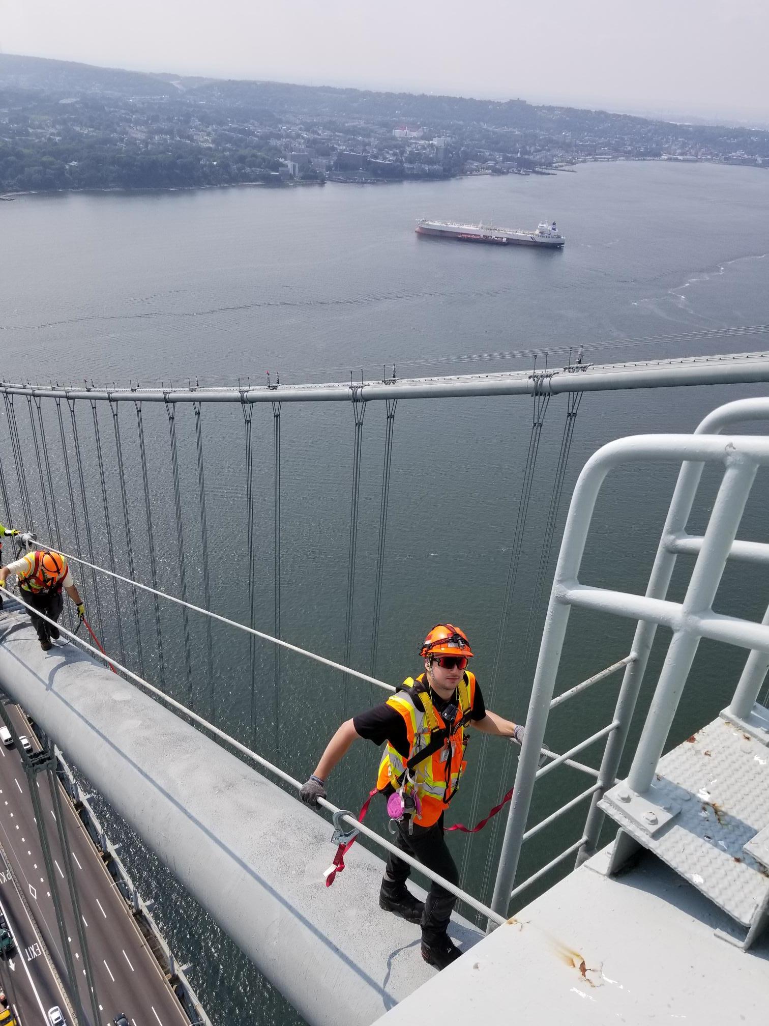 Zachar on a suspension bridge cable during an engineering inspection