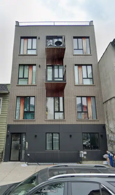 Google Maps Street View screenshot of 406 Cornelia Street showing pale brick facing, stacked central balconies and a dark ground-floor exterior.